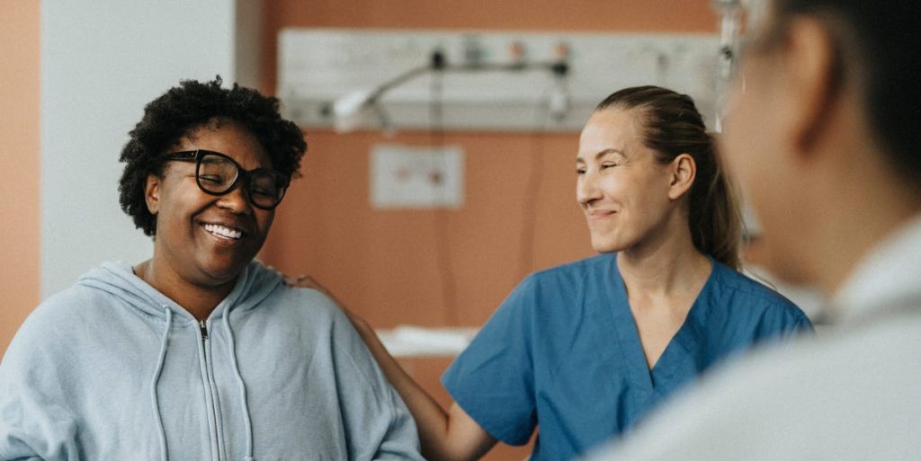 Smiling Female Nurse Consoling Happy Patient Royalty Free Image 1721410019.jpg