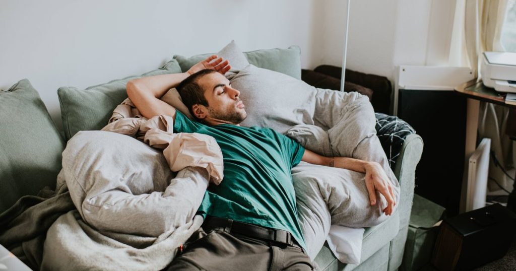 Consultant cardiologist says small step will slash cholesterol 0 a man is asleep on a sofa surrounded by duvets and pillows.jpg