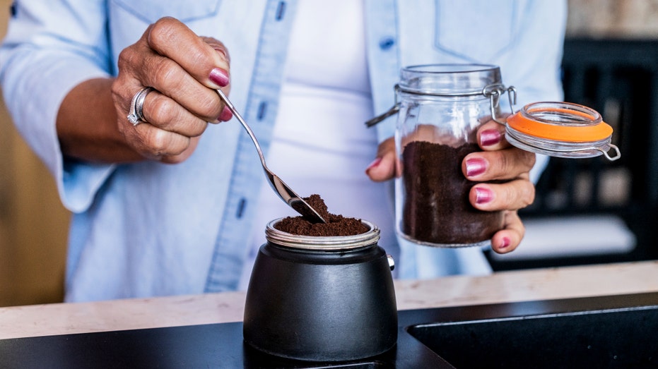 'Coffee enema' social media trend sparks health concerns among doctors Woman scooping coffee grounds.jpg