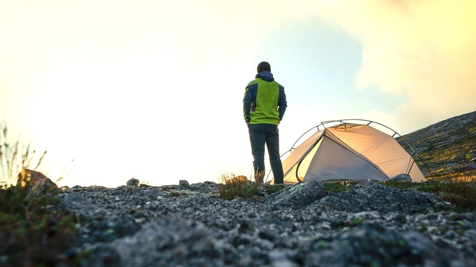 Human plague case reported, patient likely exposed while camping Man camping outdoors with tent.jpg