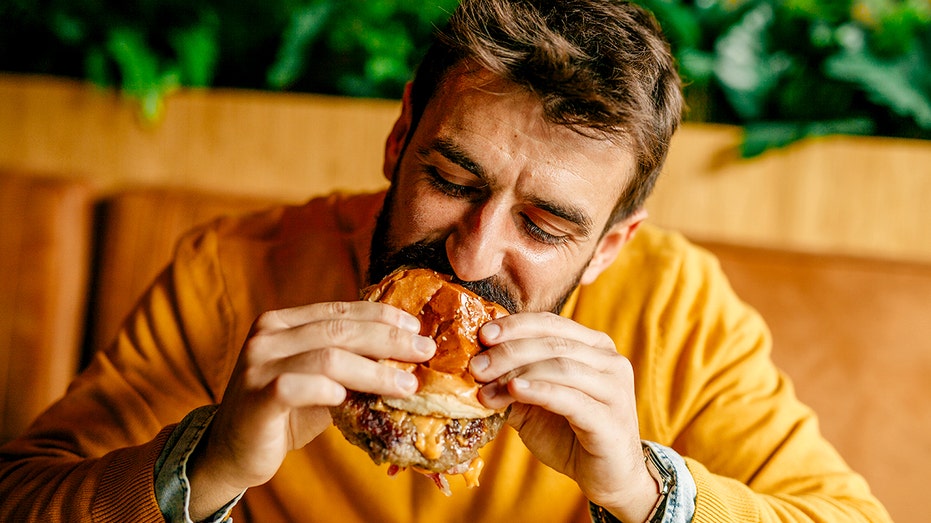 Eating meat could protect against cancer-related death, study suggests Man eating hamburger.jpg