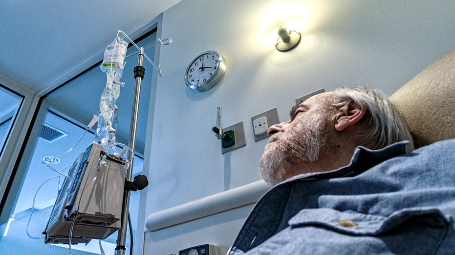 Best time of day for cancer treatment to maximize survival, according to new study Man getting cancer treatment looking at clock.jpg