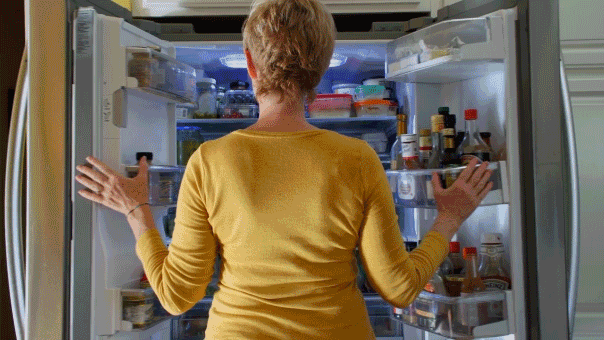 Can’t stop thinking about food? Experts point to an unexpected cause Woman looking in fridge food cravings.gif